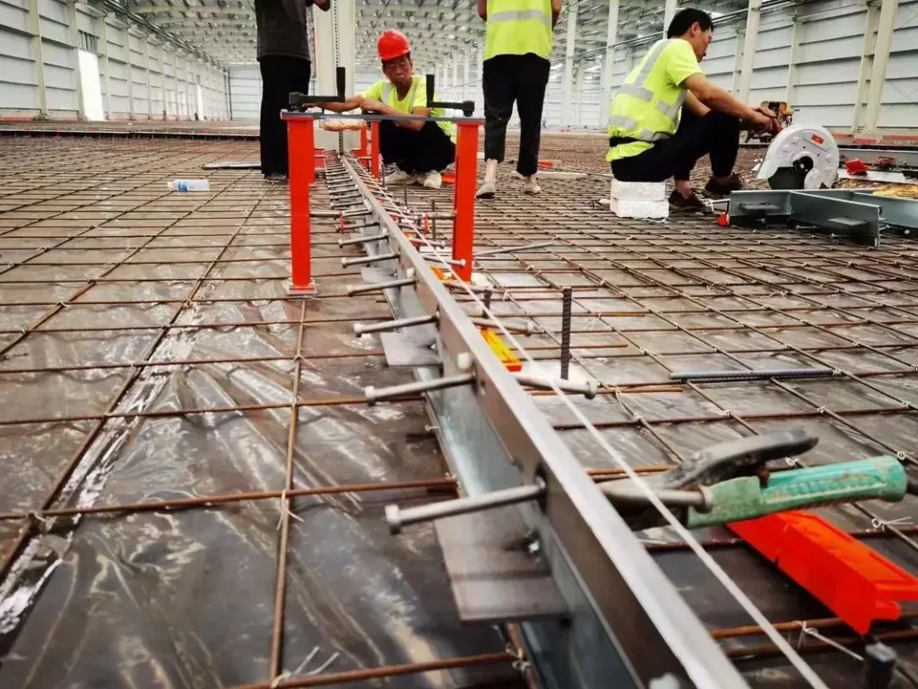 Installation of steel armored joints in an industrial concrete floor showing leveling and fixing process.